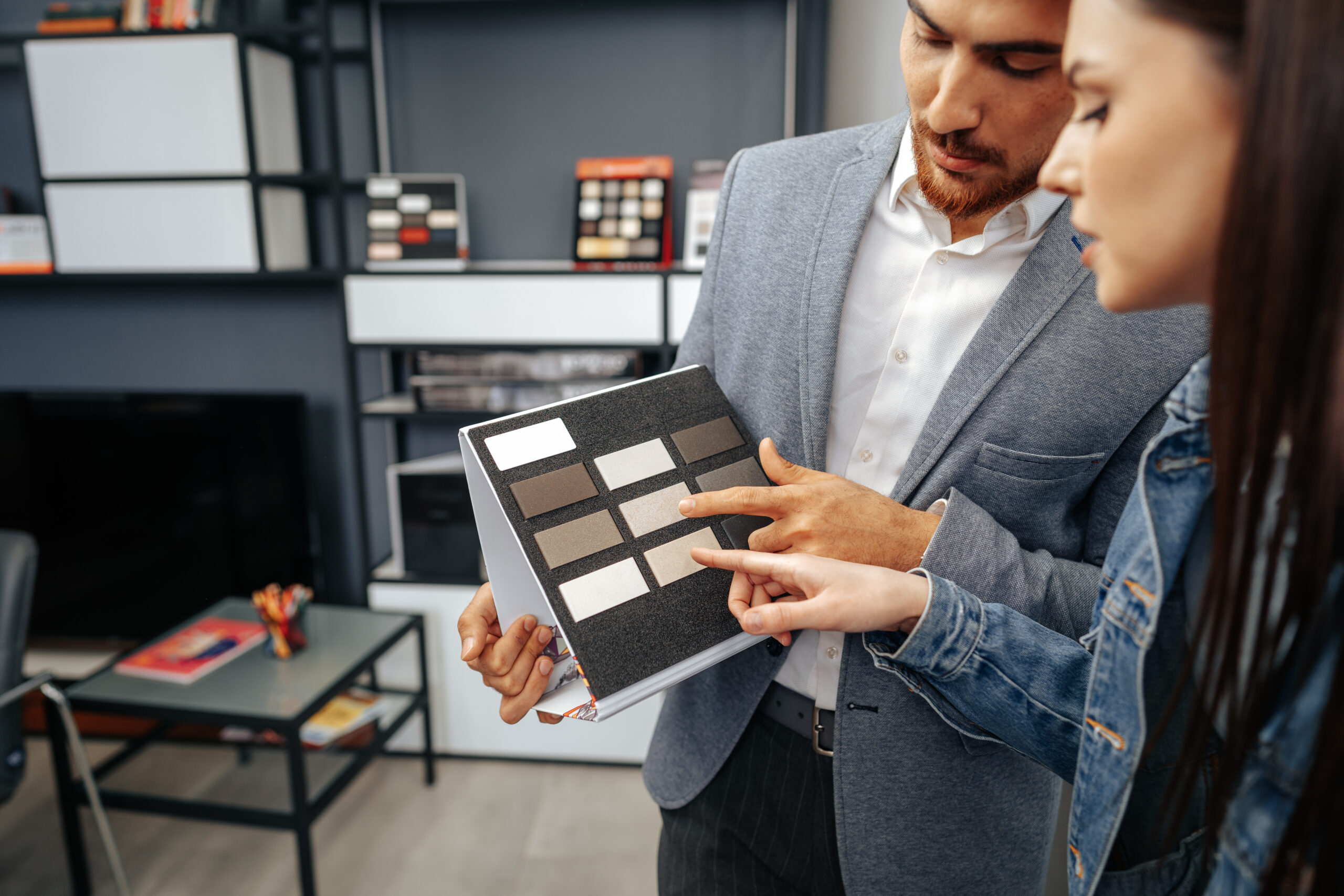 Interior Workout Services salesman shows color swatches to lady customer for new kitchen furniture